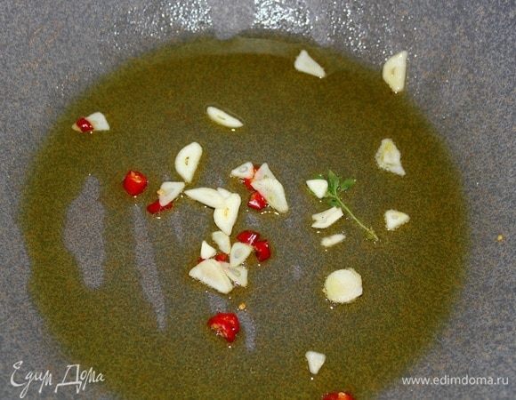 Разогреваем сковороду, наливаем оливковое масло (3–4 ст. ложки), всыпать часть нарезанного чеснока, часть веточки тимьяна и весь пеперончино (чили). Нагреть, дать маслу впитать аромат специй. В это время кипит вода, кидаем тальятелле в кипящую соленую воду.