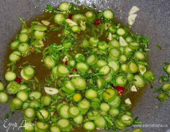 Всыпать часть нарезанных стеблей спаржи, пассеровать 2–3 минуты на слабом огне. Посолить.