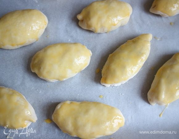 Желтки смешать с молоком. Смазать пирожки кисточкой желтком с молоком. Поставить в духовку на 50–60 минут. В конце выпечки на 10 минут температуру увеличить до 220–230°C, чтобы пирожки зарумянились. У вас может уйти чуть больше или меньше времени, следите за духовкой и пирожками.