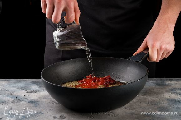 На той же сковороде соедините томаты в собственном соку, томатную пасту, вино. Добавьте сушеные травы, перец. Доведите до кипения и тушите на медленном огне в течение 10 минут. Периодически помешивайте соус.
