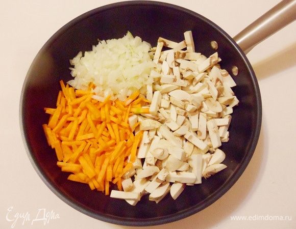 На разогретую и смазанную растительным маслом сковороду выложить лук, морковь и шампиньоны.
