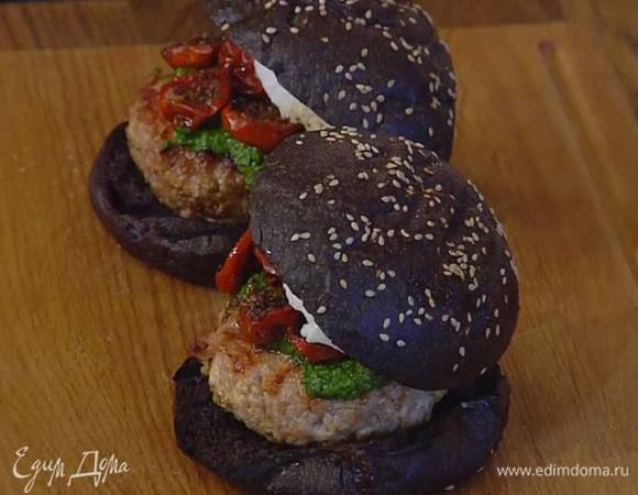 На обжаренные половинки булок выложить котлеты и смазать их соусом песто, сверху поместить вяленые помидоры, моцареллу и накрыть второй половиной булки.