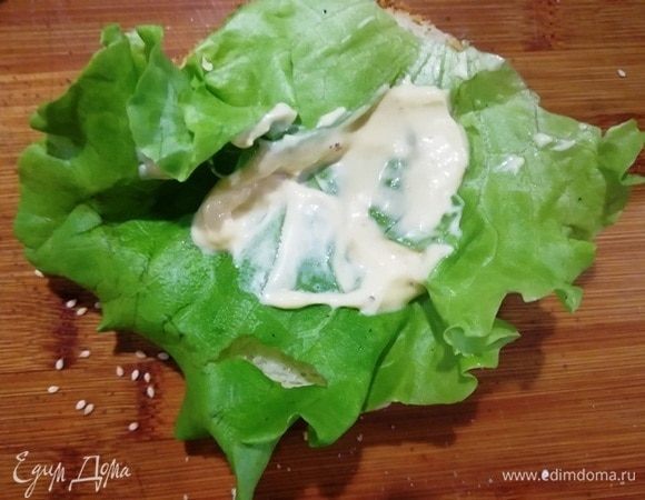 На нижнюю часть булочки кладем лист салата, смазываем его соусом (у меня майонез, горчица, соус терияки).