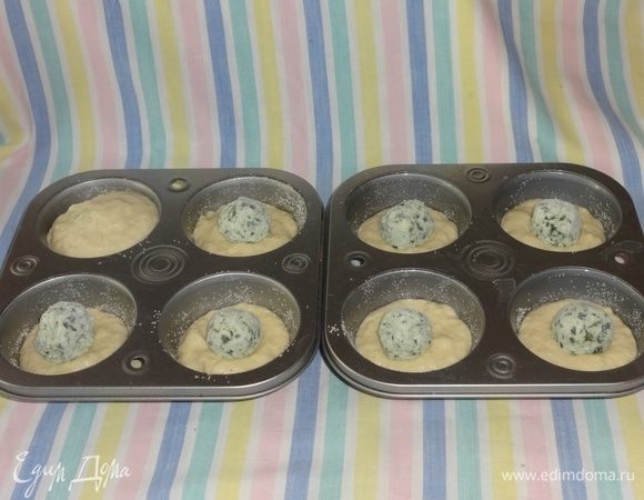 Формочки для кексов смазать растительным маслом, обсыпать манной крупой. Выложить небольшое количество теста, затем положить замороженный творожный шарик и снова тесто. Шарик должен быть полностью накрыт тестом. Форму заполнить на 3/4 объема. Поставить формы с кексами в духовку, выпекать при 180°C 20 мин. Готовые кексы выложить из формочек (забыла сфотографировать выпеченные кексы в формах).