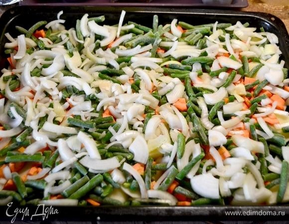 Мясо (у меня часть свиного окорока) разрезать на порционные куски (не отбивать его), натрем солью и специями. Оставим мясо мариноваться, пока подготавливаем овощи. Овощи помыть почистить. Картошку нарезать кольцами, морковь нарезать кубиком, лук нарезать полукольцами. Выложить овощи в форму, смазанную маслом. 1-й слой — картошка. 2-ой слой — морковь. 3-й слой — зеленая фасоль. 4-й слой — лук.