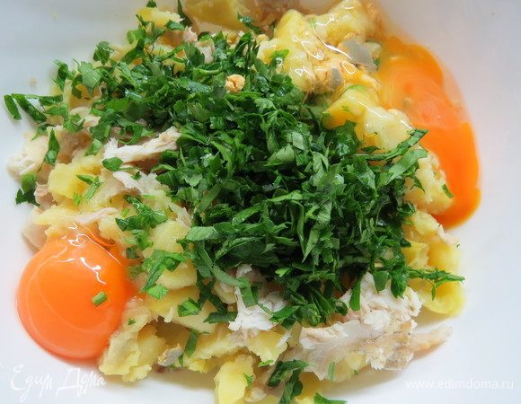 Добавить в миску к рыбе и картофелю яйца и зелень, аккуратно перемешать.