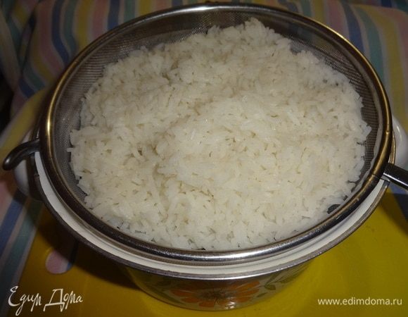 Отваренный рис откинуть на дуршлаг. Затем выложить в кастрюлю.