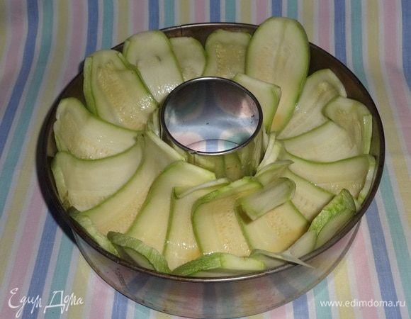 Кабачки уложить в форму-кольцо смазанной стороной вверх. Так как у меня кабачки были не слишком длинные, то некоторые пластины были короче других и не закрывали весь объем формы. Я потом, когда положила начинку, «залатывала» пустые места другими пластинами (и по внутреннему кольцу, и по внешнему), смазывая их также яйцом.