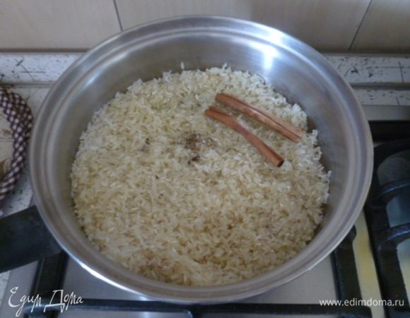 В большом сотейнике растопить сливочное масло, добавить 1,5 ст. л. оливкового. Высыпать рис. Перемешать. Добавить специи. Кардамон нужно предварительно извлечь из коробочек и растолочь в ступке.