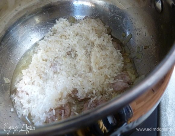 Кладем рис и немного обжарим его, пока не впитает в себя масло и не станет прозрачным.