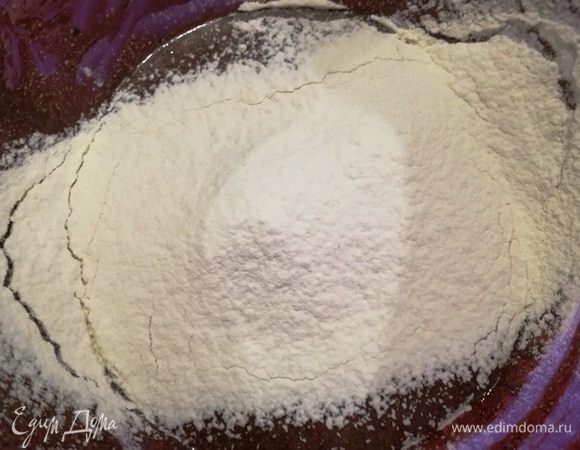 Добавляем муку и смешиваем тесто вручную.
