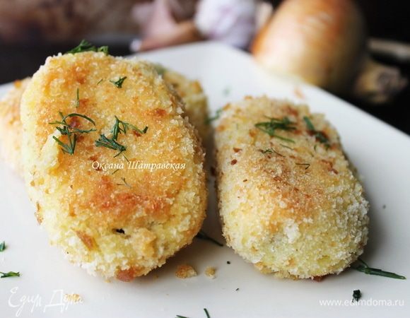 Наберите столовую ложку с горкой картофеля и влажными руками расплюсните тесто, положите ложку начинки и залепите пирожок. Панируйте в сухарях. Разложите зразы на подготовленный противень и запекайте в духовке при 180°C около 20 мин.