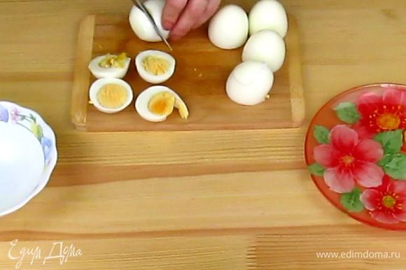 С очищенных куриных яиц снимите защитную пленочку, если она осталась на яйцах. После чистки ополосните яйца под водой, чтобы смыть оставшуюся мелкую скорлупу. Теперь от яиц отрежьте тупую сторону.