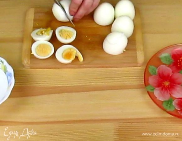 С очищенных куриных яиц снимите защитную пленочку, если она осталась на яйцах. После чистки ополосните яйца под водой, чтобы смыть оставшуюся мелкую скорлупу. Теперь от яиц отрежьте тупую сторону.