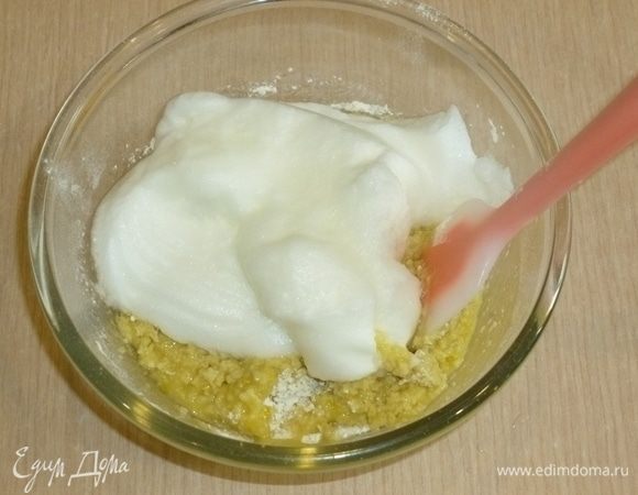 Отдельно взбить белки в пышную пену. В тесто добавить оливковое масло, мед, цедру лимонов, перемешать. Ввести белки в смесь.