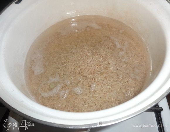 Рис Здоровье ТМ «Националь» промыть. В кастрюлю налить воды, положить рис, довести до кипения и варить 20 минут. Вообще-то этот шаг нужно было поставить первым, а пока варится рис, обжаривать овощи и рыбу. Так будет быстрее. Когда закончится время варки риса, вода почти вся впитается, останется совсем мало. Выливать ее не нужно.