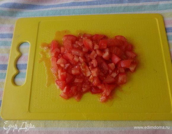 С помидора снять кожицу и нарезать его мелкими кубиками.