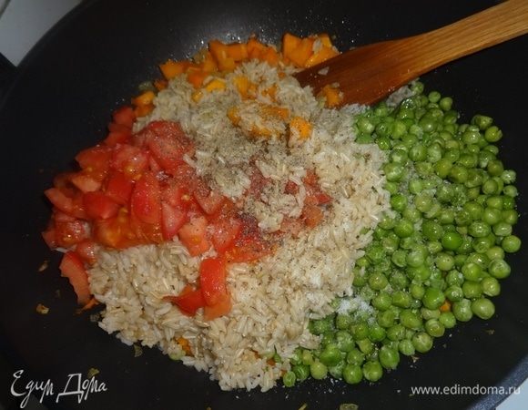 В сковороду с овощами выложить рис, горошек (не размораживая), помидоры. Посолить, поперчить, перемешать.