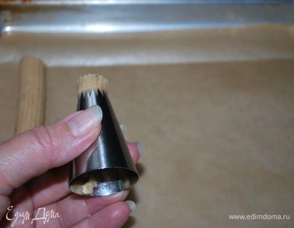 Через насадку «открытая звезда» формируем печенье-палочки и выкладываем их на пергамент.