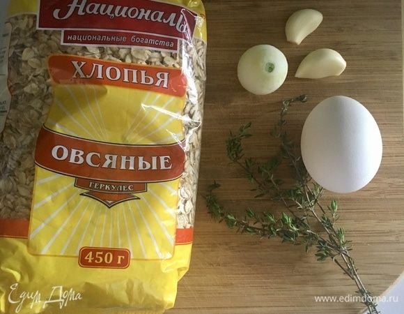 Блюдо начнем с приготовления тефтелей. Первым делом, конечно, нам понадобится фарш. У меня фарш говяжий. Зачастую в тефтельки добавляется рис. Сегодня же я предлагаю изменить проверенной классике и добавить в фарш высококачественные овсяные хлопья ТМ «Националь», которые замечательно проявили себя в этих мясных шариках. Далее необходимо почистить одну небольшую луковицу, пару зубчиков чеснока, одно яйцо и столовая ложка листиков свежего ароматного тимьяна.