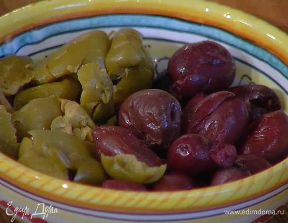 Оливки раздавить плоской стороной ножа и вынуть косточки.