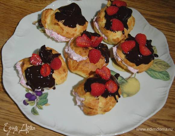 Эклеры надрезать сбоку и наполнить малиновым кремом, верхушку обмакнуть в шоколадную глазурь и украсить разрезанной пополам свежей малиной.