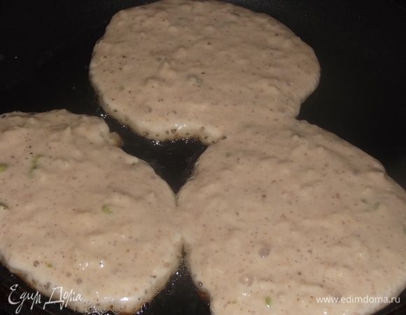 На раскаленную сковороду с маслом ложкой выложить оладьи.