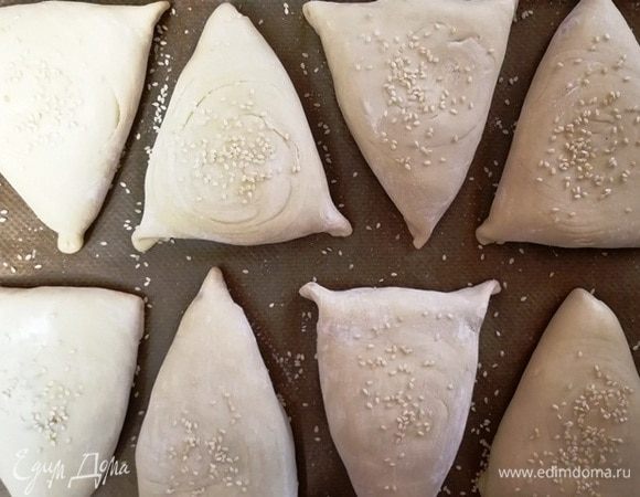 Выкладываем на противень швом вниз. Смазывать ничем не надо. Я зачем-то на этом этапе посыпала самсу кунжутом. Можете не делать этого, посыпем позднее.