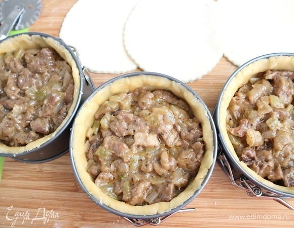 Духовку разогреть до 190–200°C. Достать из холодильника начинку, формочки с песочным тестом. Положить в формочки начинку из мяса и овощей.