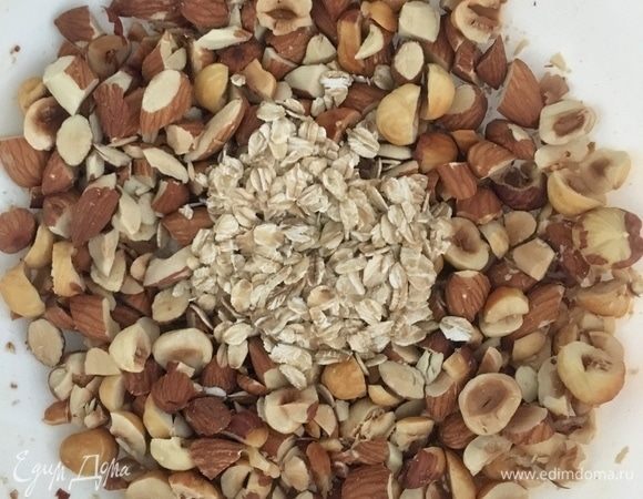 Орехи порубить не очень мелко. Соединить в миске рубленые орехи с овсяными хлопьями. Добавить кокосовое масло и кленовый сироп, все перемешать. Овсяно-ореховый крамбл для полезной сладости готов, все очень легко и просто.