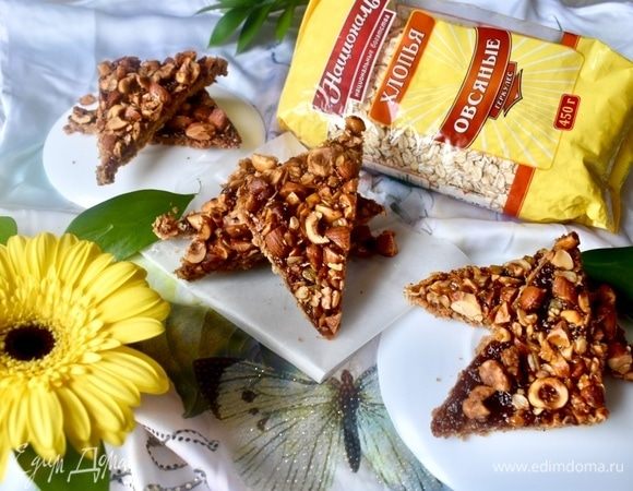 Очень оригинальные на вкус уголки получаются! Текстура интересная: основа мягкая, тягучая благодаря тому, что полностью пропитывается джемом, который дает сладко-кисловатый оттенок. Верхушка хрустящая, насыщенная карамелизированными орешками и овсяными хлопьями. Верхушка напоминает любимую многими и мной в том числе гранолу, только запеченную в виде печенья.