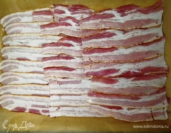 Выкладываем бекон на пергаментную бумагу. С помощью нее удобно сворачивать рулет.