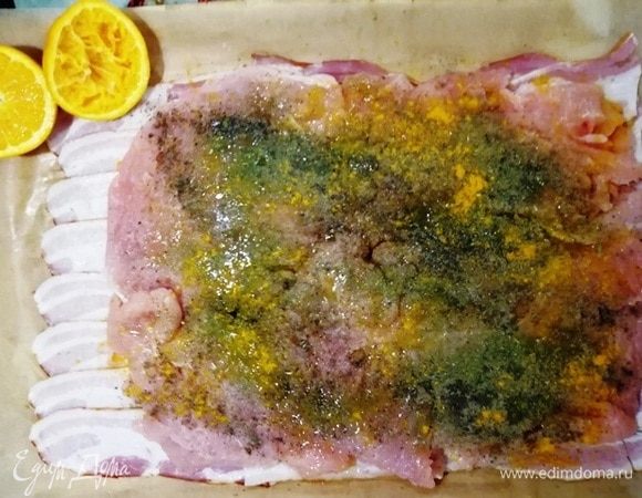 Посыпаем индейку сухими специями. Польем соком половинки апельсина.