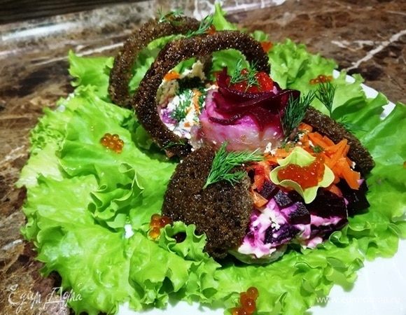 А для порционной подачи я подсушиваю в духовке черный хлеб, сбрызнутый оливковым маслом. Формой вырезаю у него серединку. Такие тосты приятно дополняют салат. Украшаю салат красной икрой и зеленью.