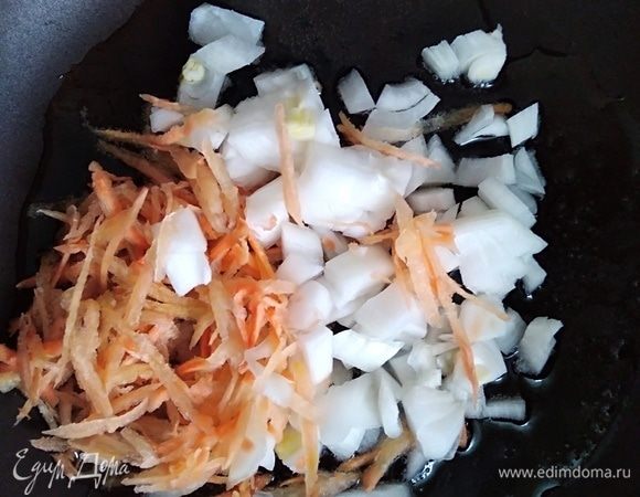 В сковороде разогреть 2 ст. л. масла, добавить тертую морковь и нарезанный лук. Пассировать 5 минут, помешивая.