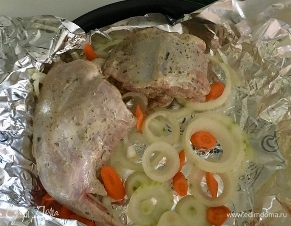 Берем форму, в которой будем запекать кролика. Выстилаем ее фольгой для запекания, формируя при этом карман. На дно формы разложить колечки лука и брусочки моркови. На эту луково-морковную подушку разложить кусочки кролика.