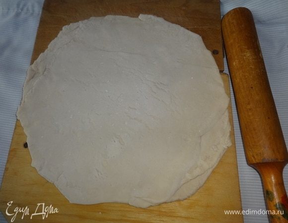 Раскатать тесто на подпыленной мукой поверхности, по размеру больше диаметра формы на 3–4 см.