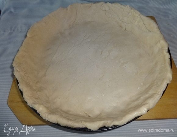 Форму для выпечки смазать растительным маслом и распределить в ней тесто, формируя бортики.