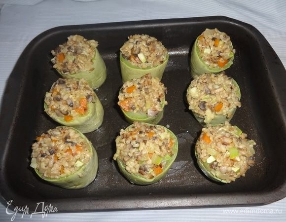 Форму смазать частью растительного масла (основные). В кабачковые стаканчики разложить начинку и поставить их в форму. У меня осталось немного начинки, буквально на 1 стаканчик.