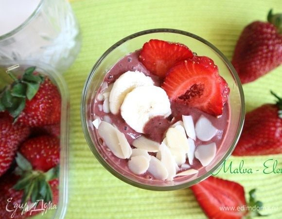 Вылить смузи в стакан, нарезанную на кусочки часть клубники «утопить» в смузи, сверху поместить кружочки банана, миндальные лепестки, пластинки клубники. Приятного аппетита и хорошего дня!