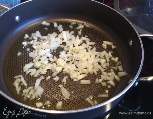 Разогрейте сковороду, налейте оливковое масло и обжарьте на сильном огне лук и чеснок, добавьте курицу и жарьте, помешивая около 5 минут.