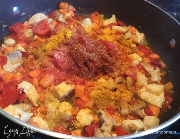 Сделайте огонь тише, добавьте помидоры в собственном соку, посолите, приправьте перцем, шафраном и паприкой, налейте вино и перемешайте.