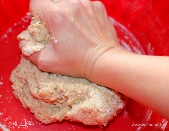 Начать замешивать тесто. Гречневая и льняная мука очень хорошо впитывают влагу поэтому потребуется добавить немного воды. Добавляйте воду постепенно, продолжая месить тесто.