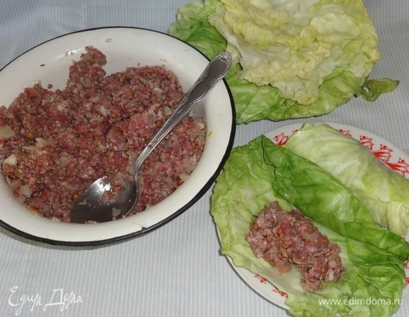 На капустный лист со стороны жилки выкладывать фарш, примерно 1 ст. л. В большие капустные листья пойдет чуть больше фарша, в маленькие чуть меньше.