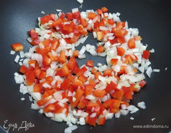 В сковороде разогреть растительное масло, обжарить лук 1 минуту. Затем добавить перец и также обжарить в течение минуты.