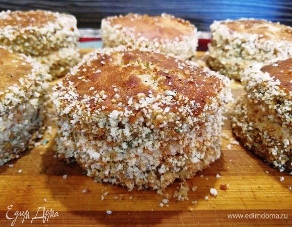 Обваливаем бока пирожных в бисквитной крошке.