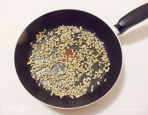 Слегка обжарить семечки на сухой сковороде.