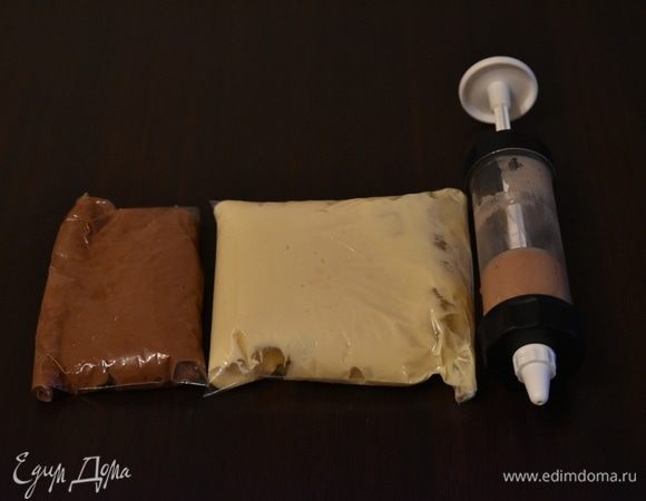 Разделить тесто на три неравные части. В 80 г белого теста добавить 0,25 ст. л. какао и 0,5 ст. л. муки. В 150 г теста добавить 2 ст. л. какао. В оставшееся белое тесто добавить 2 ст. л. муки. Разложить все три цвета по пакетам. Срезать у пакетов уголки.