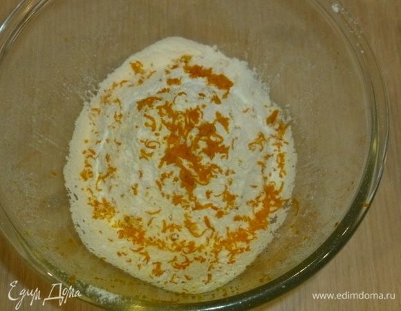 Масло заранее достать из холодильника, чтобы оно стало комнатной температуры. Разогреть духовку до 180°C. Муку с разрыхлителем просеять в большую миску, добавить щепотку соли. Натереть цедру апельсина.