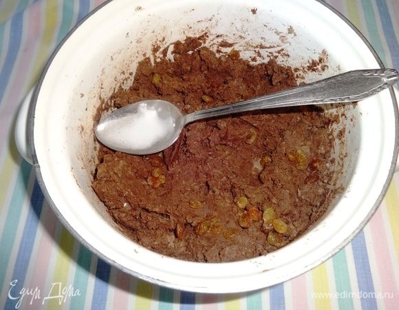 В тесто выложить изюм, положить гашенный уксусом разрыхлитель, еще раз перемешать.